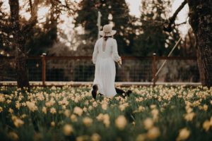 woman walking through daffodils