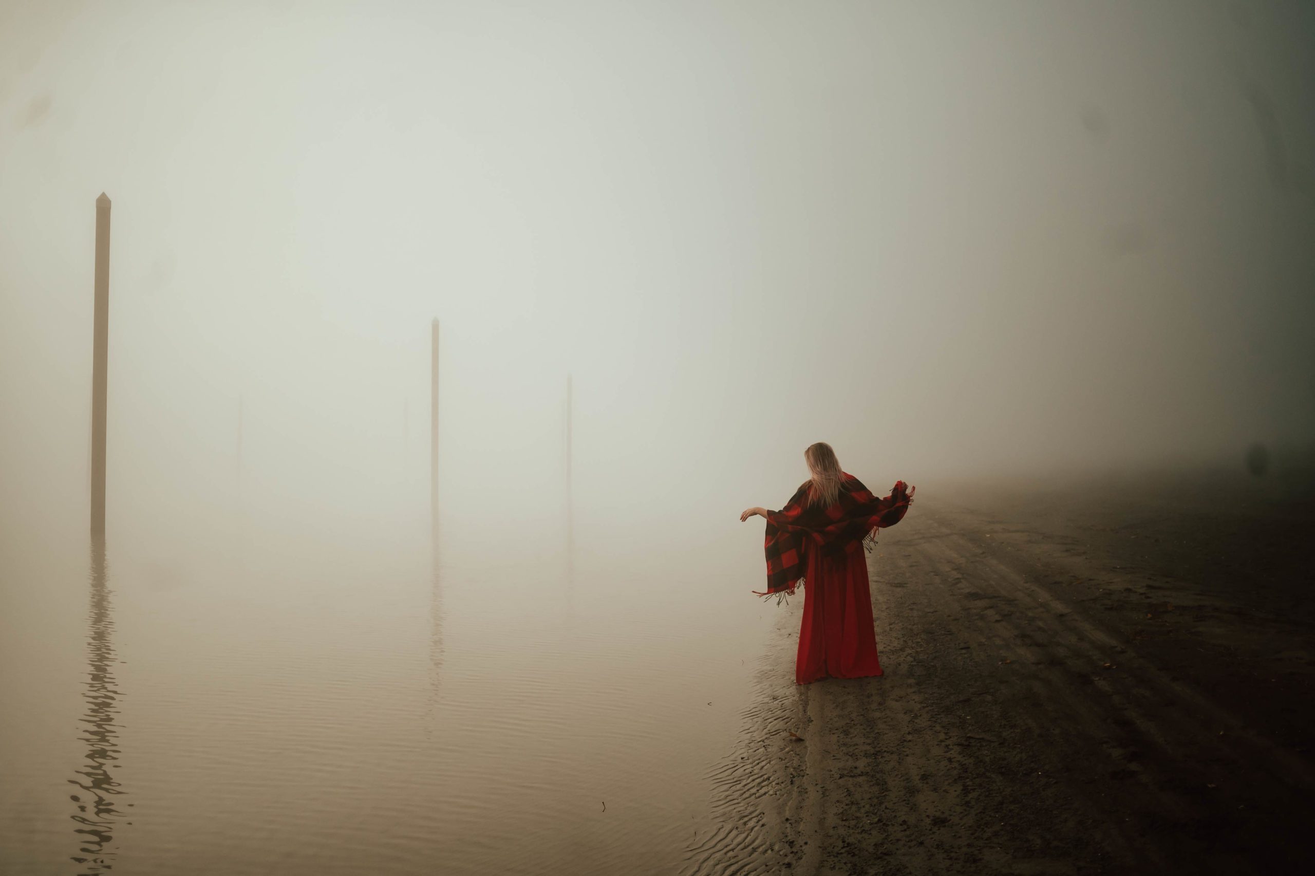 woman walking by foggy river