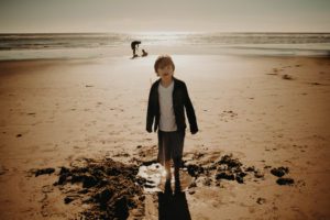 Boy standing in puddle at ocean