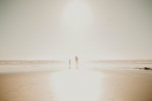 Grandpa and girl walking on beach