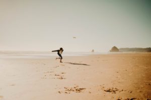 Boy playing frisbee on beach