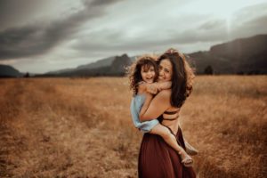Mom and daughter laughing in tall grass