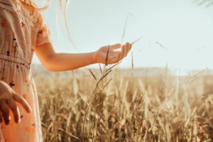 Girl touching grass in the sunshine