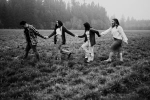 Four teens walking hand in hand in the field