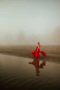 Woman in red dress by the river