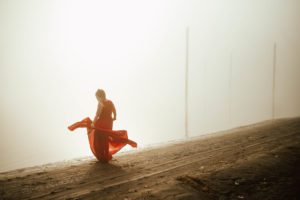 Red dress woman dancing in fog
