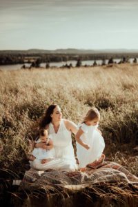 Mom and two daughters in the tall grass