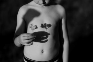 BNW image of boy with flower shadow on his bellly