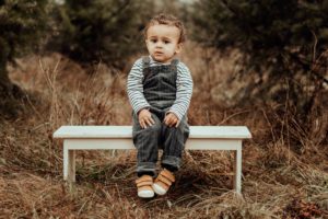 Little boy on a bench in woods