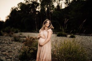 Expecting mama in pink dress with windblown hair
