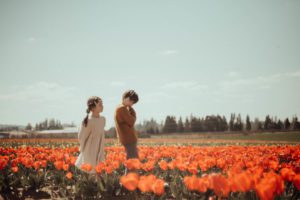 Boy and girl standing in red tulips