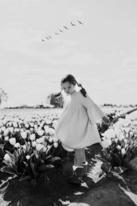 Little girl spinning in Portland tulip fields