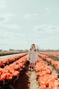 Girl in white dress yelling in tulip field