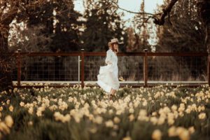 Woman swishing white dress in a daffodil field
