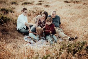 Family snuggling and laughing in a field