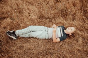 Young boy laying I golden grass