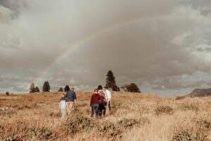 Family walking beneath a rainbow