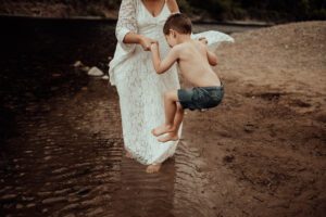 Mom helping son jump into water