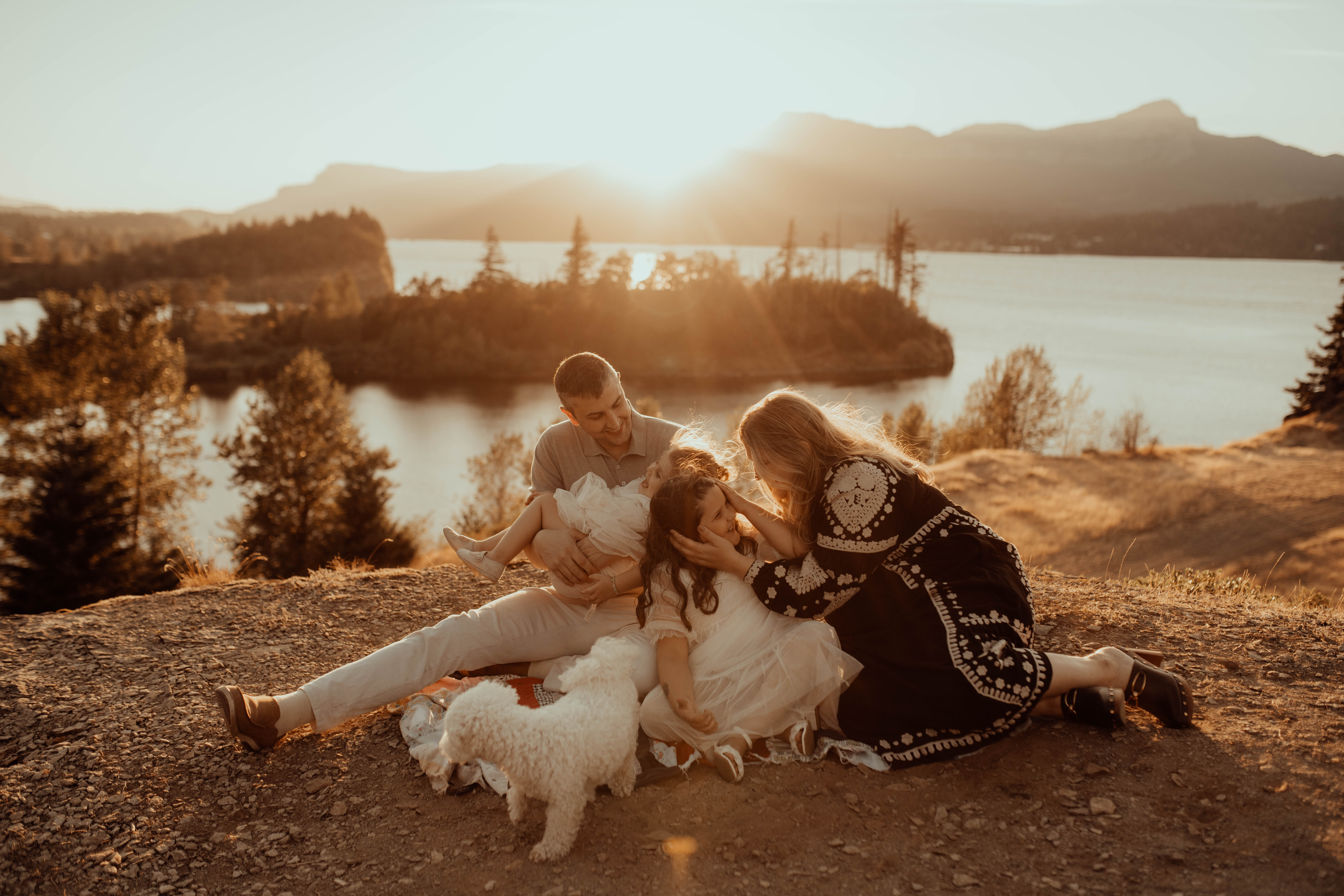 Family of four snuggling overlooking the Columbia River