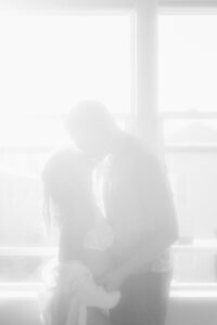 Couple silhouetted in front of their window
