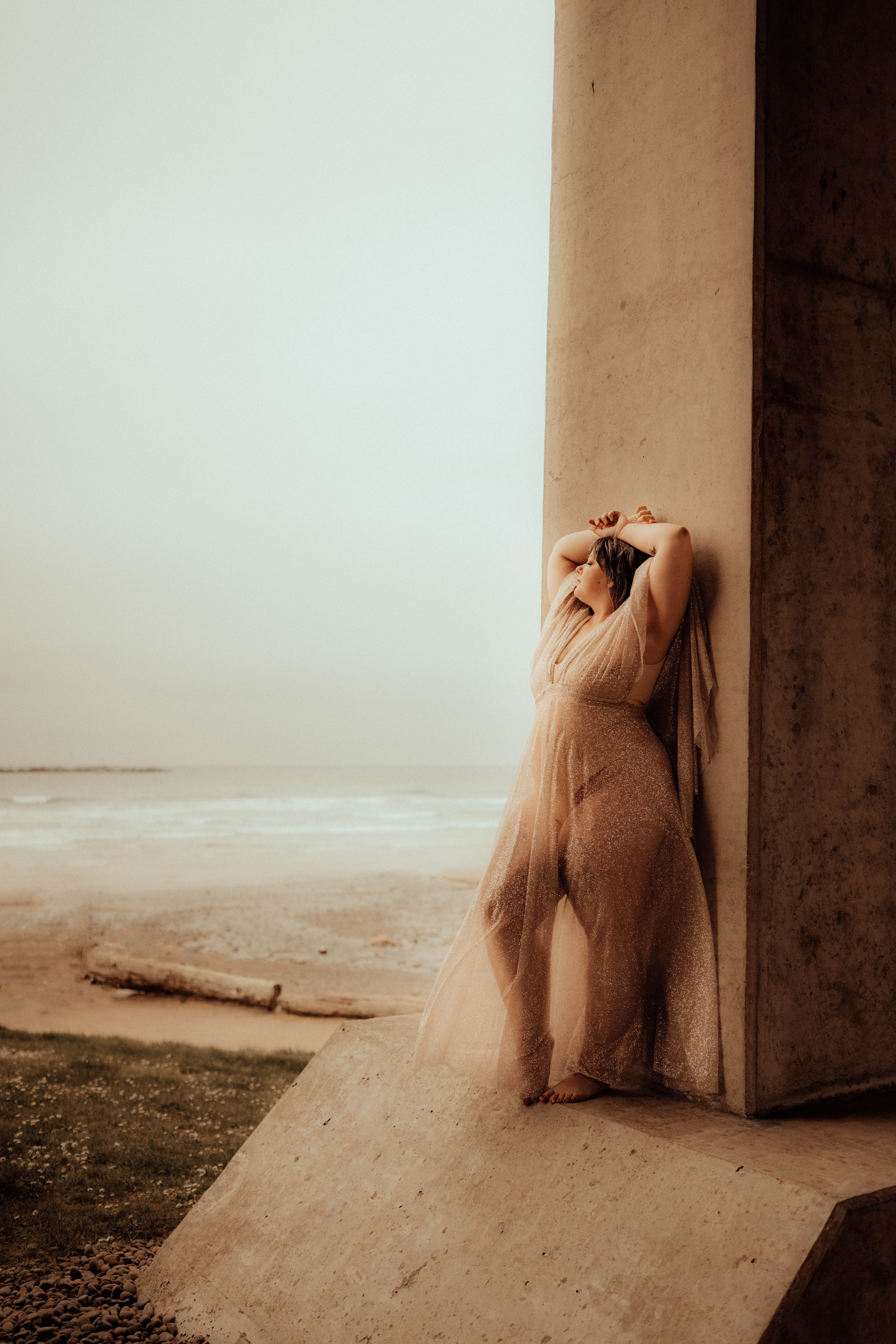Woman model underneath a bridge at the coast
