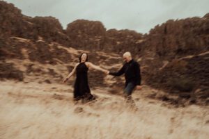 Motion blurred image of couple in front of Wild West cliffs