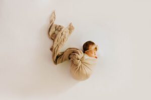 Baby girl swaddled in brown muslin