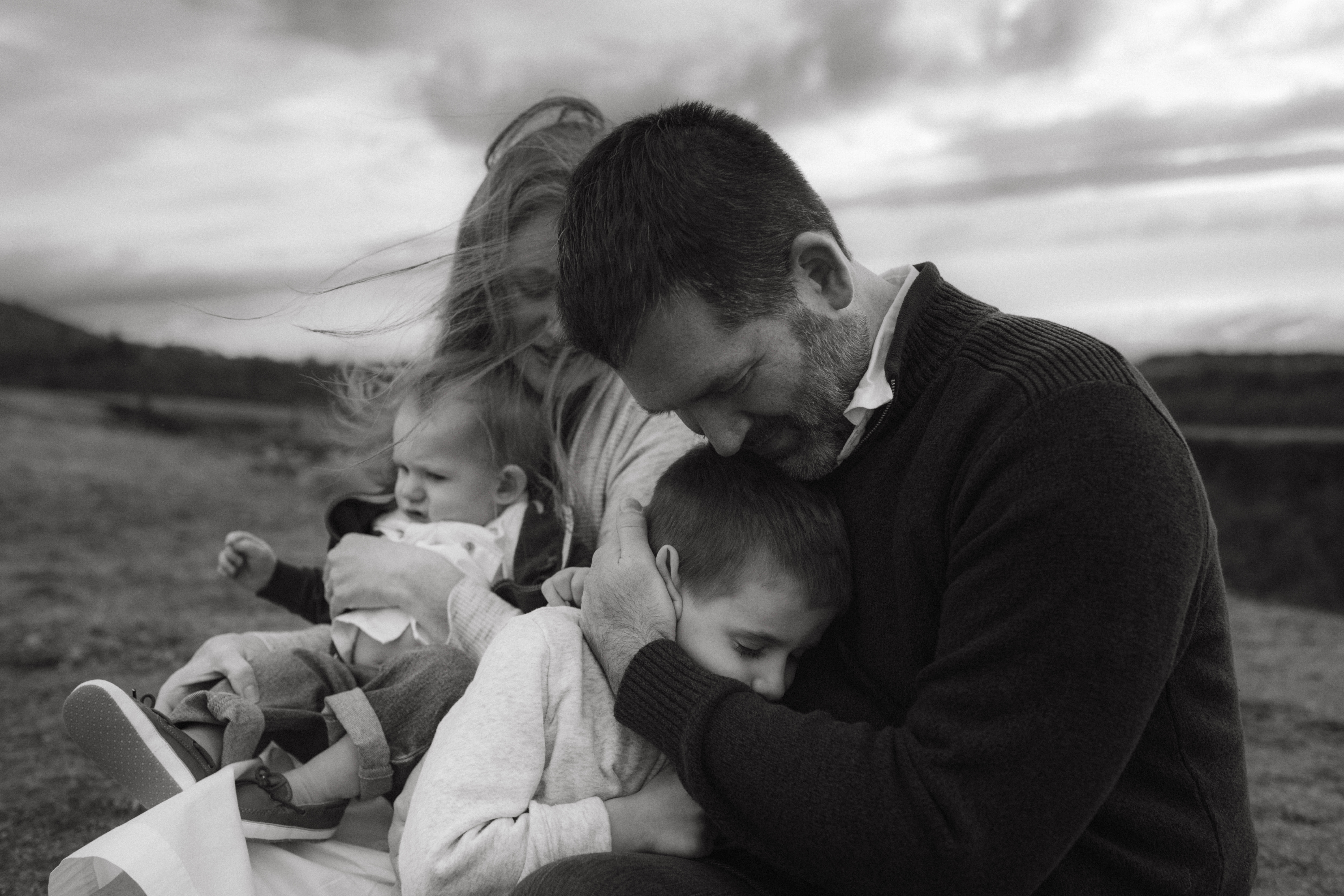 Black and white image of family of four in the wind